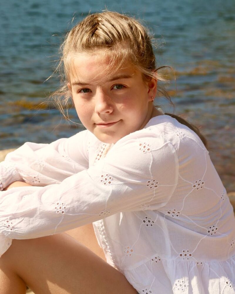Portrett av en jente i hvit bluse ved vannet